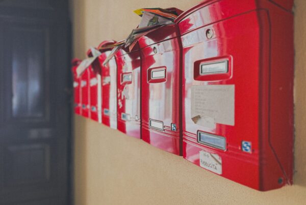 Row of red mailboxes overflowing with unread mail